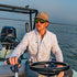 man driving boat wearing the skiff shirt
