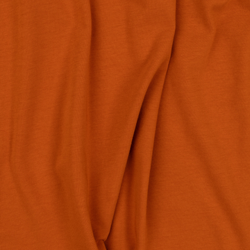 Close-up of soft, rust-colored fabric texture from The Speedway shirt, showing natural folds and smooth feel
