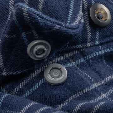 Close-up of button detail on The Sturgeon navy plaid shirt fabric
