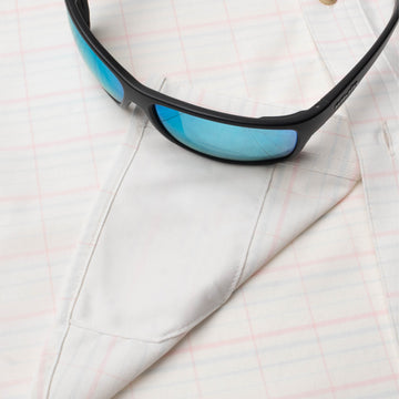 Closeup of sunglasses with lens cleaner on shirt