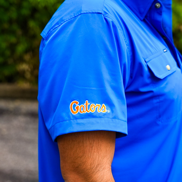 Close-up of a blue shirt sleeve with orange "Gators" logo, part of The Swamp Chomp collection