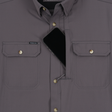 Close-up of The Tripletail shirt showing two front buttoned pockets and a smartphone partially tucked inside the left pocket.