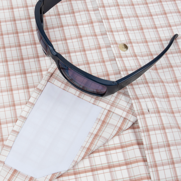 Closeup of sunglasses with lens cleaner on shirt