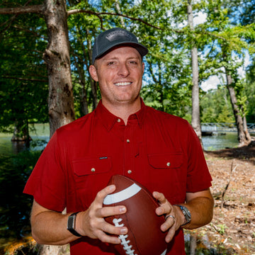 man wearing red short sleeve shirt holding football