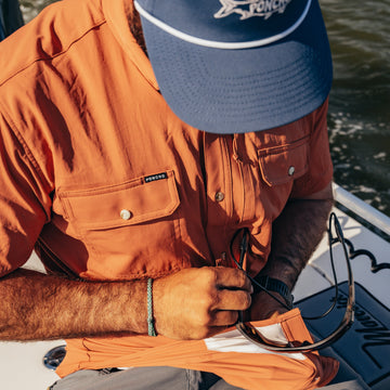 Man on boat using lens cleaner