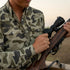 Man holds rifle while wearing The Zenaida shirt