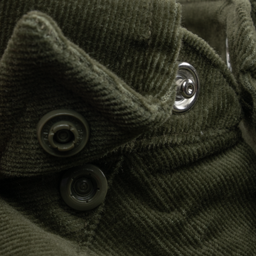 Close-up of textured olive green fabric and buttons on The Zilker shirt, highlighting fine details and stitching.