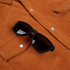 Detail shot of sunglasses in holder on orange corduroy shirt