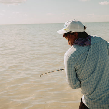 Man hooked up to fish showing the back of the Boca Grande shirt