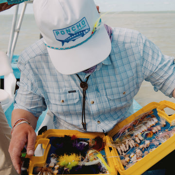 Man looking at fly box in the Boca Grande shirt