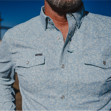 Cowboy wearing blue paisley western shirt on a ranch