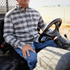 man riding a four wheeler while wearing a black plaid flannel shirt