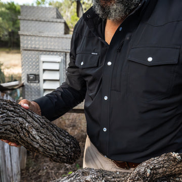man carrying wood wearing black long sleeve tuff-thread shirt