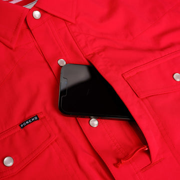 closeup of phone going into red shirt chest pocket