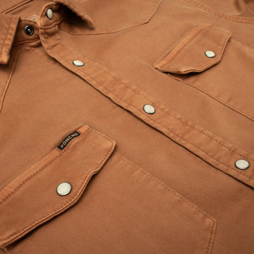 close up of burnt orange denim pearl snap pockets
