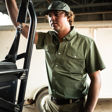 man with four wheeler wearing green short sleeve tuff-thread shirt