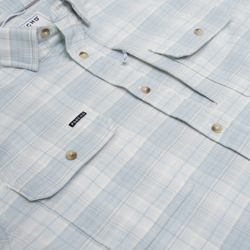 Close up photo of blue plaid flannel shirt with button pockets