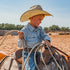 Photo of young kid riding a horse and roping