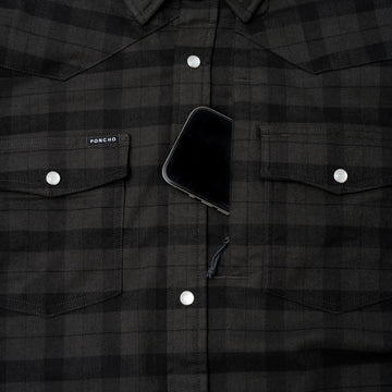 Phone in hidden chest zippered pocket of pearl snap flannel shirt