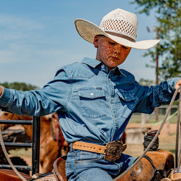 Young cowboy riding a horse and getting ready to rope