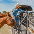 Young cowboy petting his horse wearing dark denim