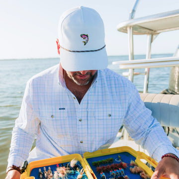 Man on boat wearing trout hat