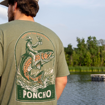 man wearing trout rider tee next to water