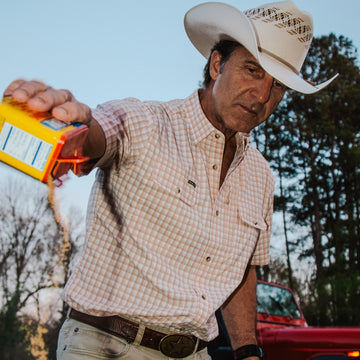 man wearing red plaid shirt with spice jar
