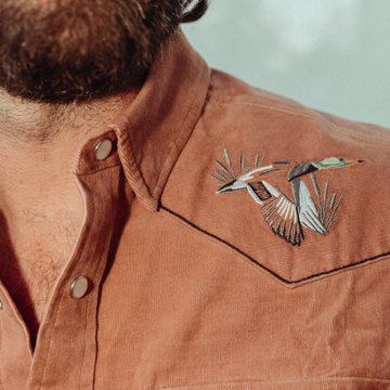 closeup of man with duck logo shirt