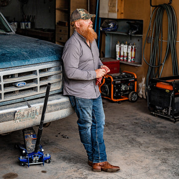 man wiping his hands in a garage after fixing truck