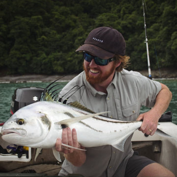 man holding roosterfish in grey short sleeve shirt