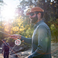 Man wearing long sleeve blue shirt fly fishing