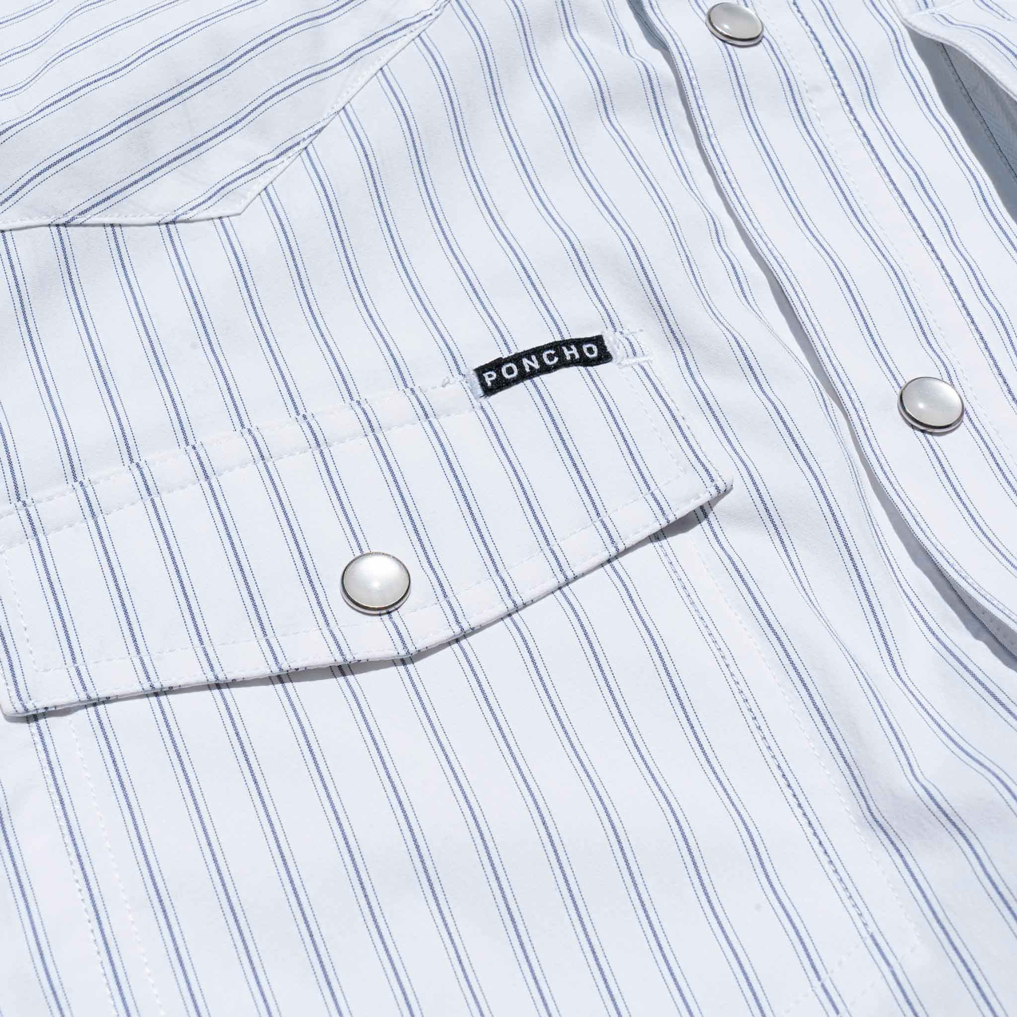 Close up of front pocket with pearl snaps on striped western shirt