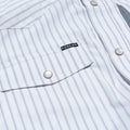 Close up of front pocket with pearl snaps on striped western shirt