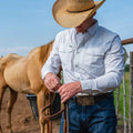 Man wearing striped long sleeve shirt in front of horse