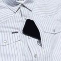 Close up of phone going into the front chest zipper pocket of the striped western shirt