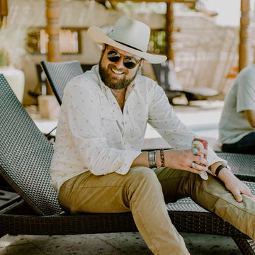 man sitting on bench with beer in hand