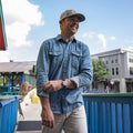 man waking rolling up sleeve, wearing denim western