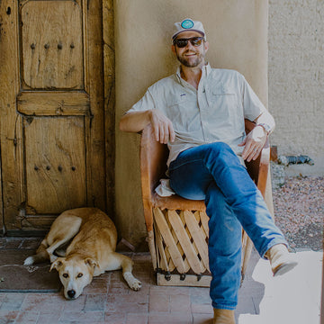guy sitting in chair next to dog
