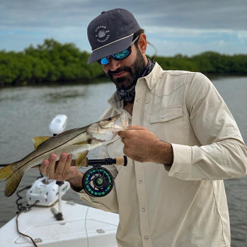 long sleeve tan western shirt  man fishing in blue hat