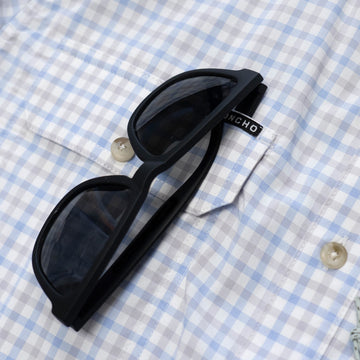 Blue & Grey plaid shirt shirt sleeve sunglass close up