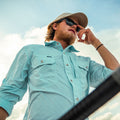man wearing long sleeve aqua shirt