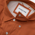 Close up of the burnt orange shirt collar snaps