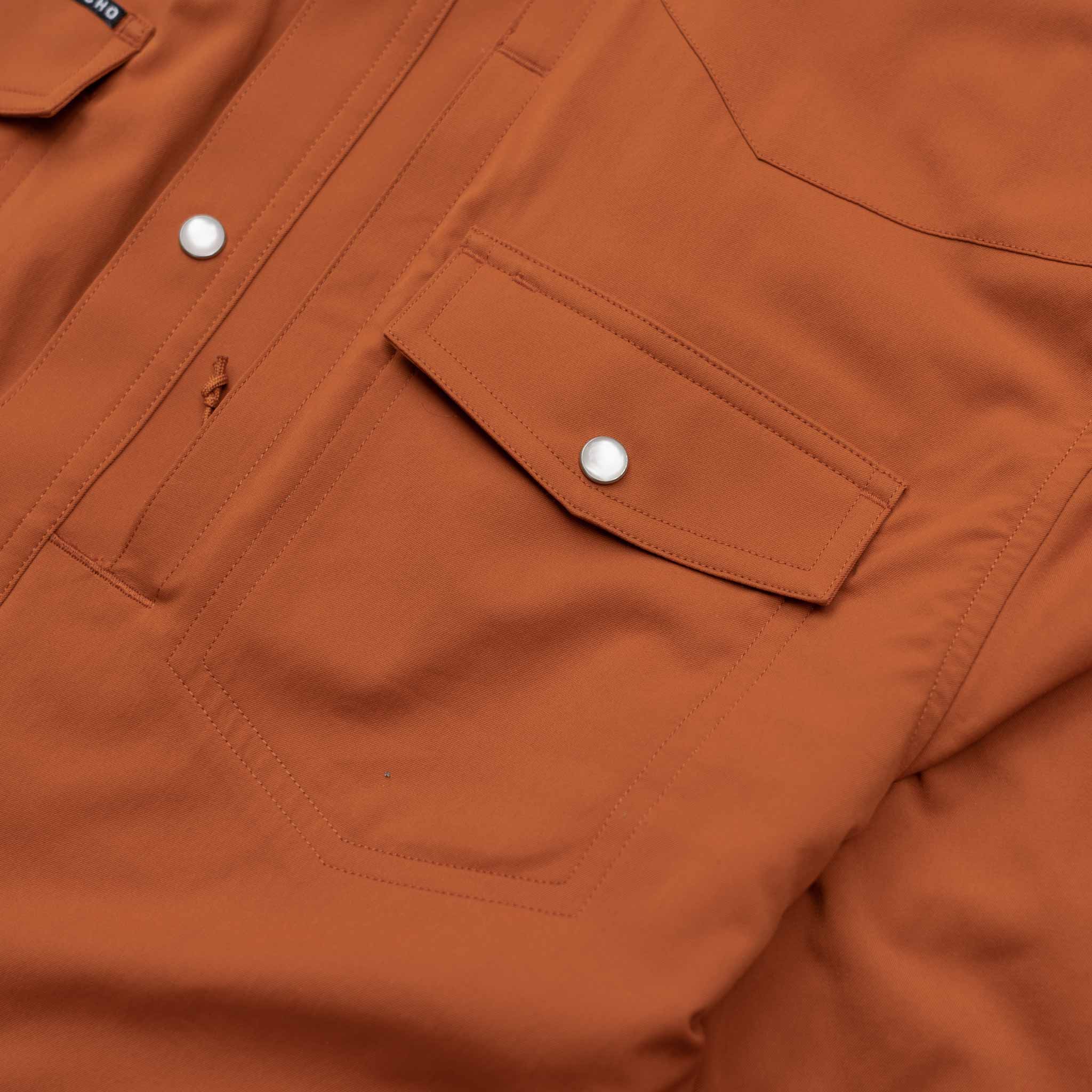 Close up of the pearl snap pockets on the burnt orange shirt