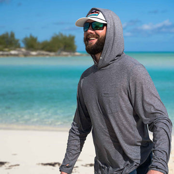 man on the beach wearing grey hoodie