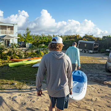men holding kayak wearing grey hoodie