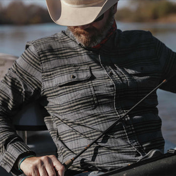 man wearing plaid flannel with grey and olive fabric