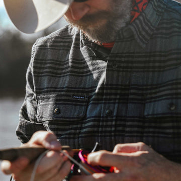close up of man wearing plaid flannel with grey and olive fabric