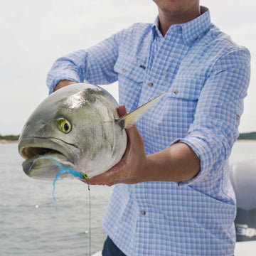 Man in blue plaid shirt with fish