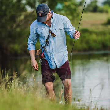 Man with fishing gear in blue shirt